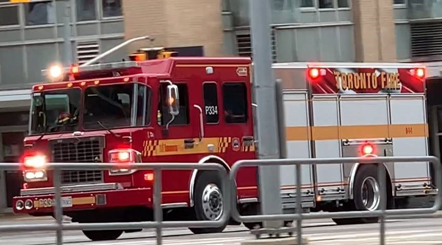 A Toronto Fire Services fire truck seen driving with its lights flashing.