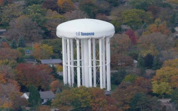 A Toronto Water tower surrounded by fall foliage.